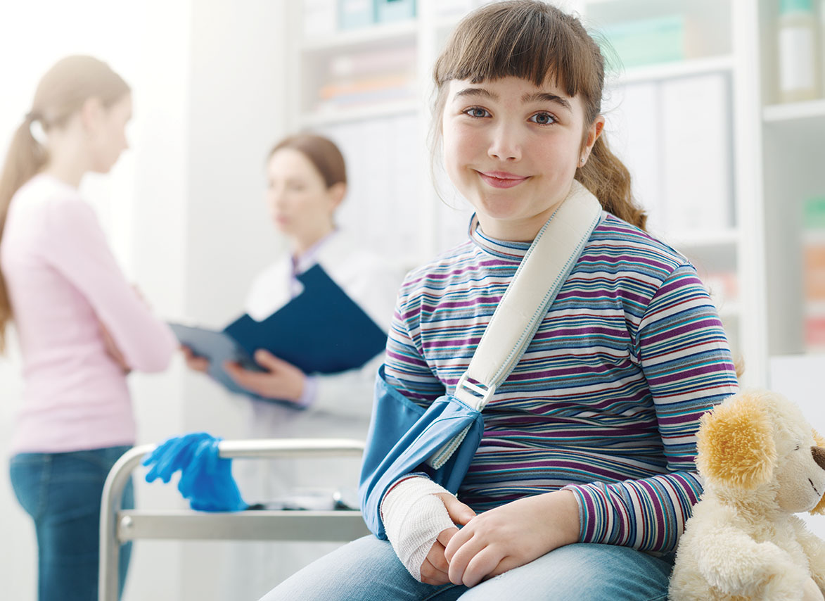 Happy girl with cast at doctor's office